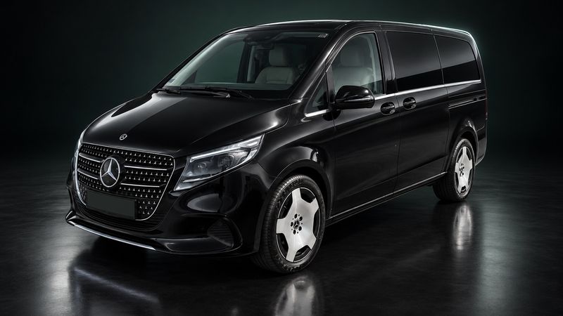 Black Mercedes-Benz V-Class of our fleet in a dark studio, front three-quarter view